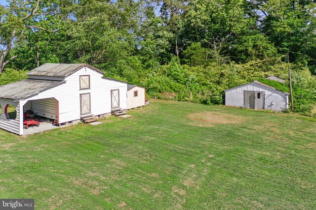 1838 Muddy Gut Rd, Dunnsville, VA 22454 - view of green lawn with entry steps and an outdoor structure
