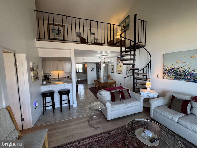 911 Harbour House Rd Unit 911, Bethany Beach, DE 19930 - living room with a high ceiling, stairway, wood finished floors, baseboards, and a chandelier