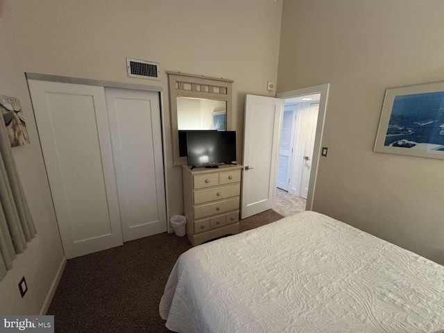 911 Harbour House Rd Unit 911, Bethany Beach, DE 19930 - bedroom with dark colored carpet, a closet, a towering ceiling, and baseboards