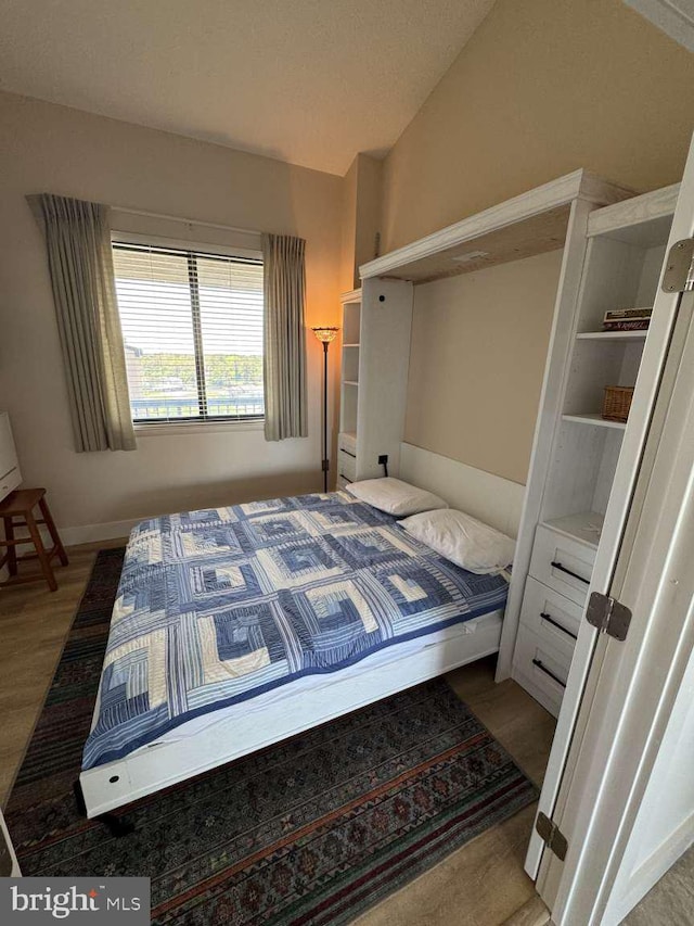911 Harbour House Rd Unit 911, Bethany Beach, DE 19930 - bedroom with wood finished floors, vaulted ceiling, and baseboards