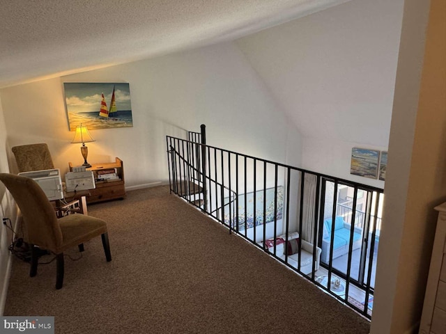 911 Harbour House Rd Unit 911, Bethany Beach, DE 19930 - hallway with lofted ceiling, carpet, a textured ceiling, and an upstairs landing