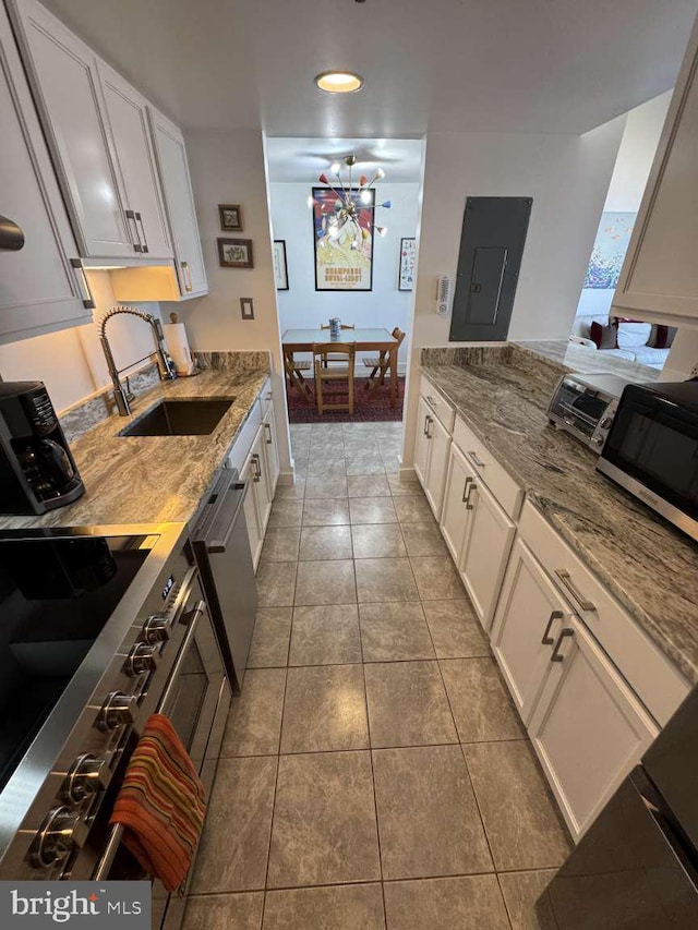 911 Harbour House Rd Unit 911, Bethany Beach, DE 19930 - kitchen featuring a sink, stainless steel appliances, light stone counters, tile patterned floors, and white cabinets