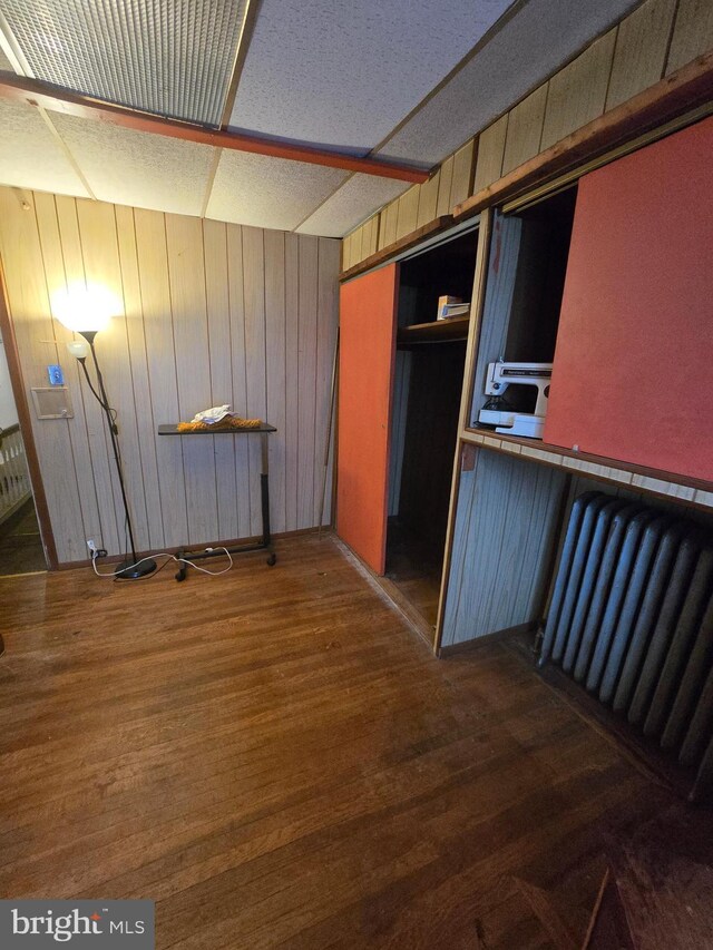 233 S 58th St, Philadelphia, PA 19139 - unfurnished dining area featuring radiator, wood finished floors, and wood walls