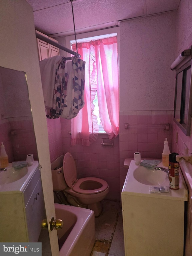 233 S 58th St, Philadelphia, PA 19139 - full bath with tile walls, plenty of natural light, toilet, vanity, and a bath