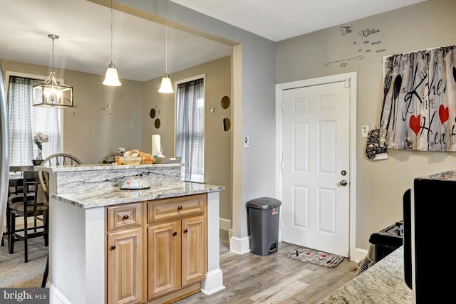 5109 Ivanhoe Ave, Baltimore, MD 21212 - kitchen with light wood-type flooring, light stone countertops, decorative light fixtures, a kitchen bar, and baseboards