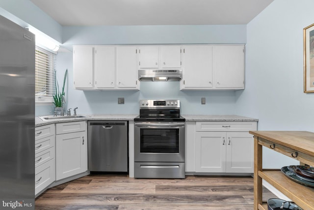 18 Huxley Cir, Abingdon, MD 21009 - kitchen with stainless steel appliances, under cabinet range hood, a sink, white cabinets, and light wood-style floors