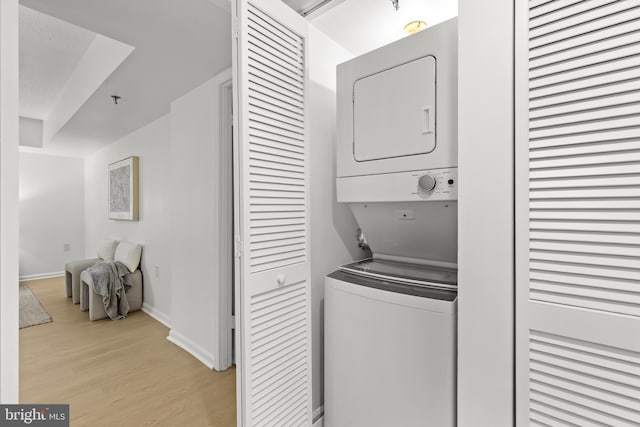 1001 N Randolph St Unit 910, Arlington, VA 22201 - laundry room with stacked washer / dryer, light wood-style floors, and baseboards