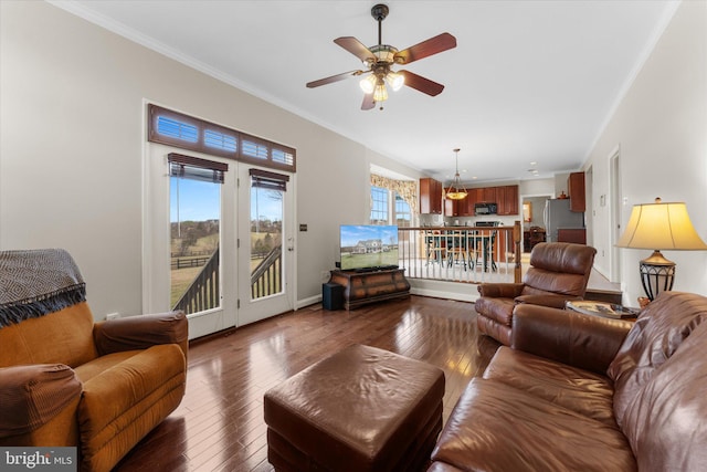 living area with ceiling fan, dark wood finished floors, ornamental molding, and baseboards