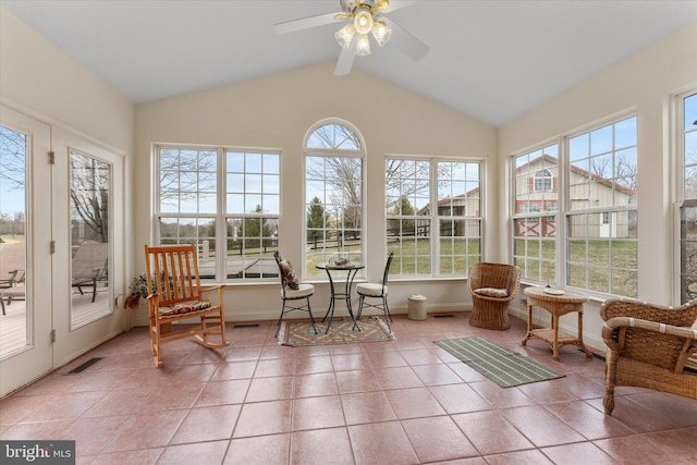 sunroom / solarium featuring lofted ceiling, baseboards, and tile patterned flooring