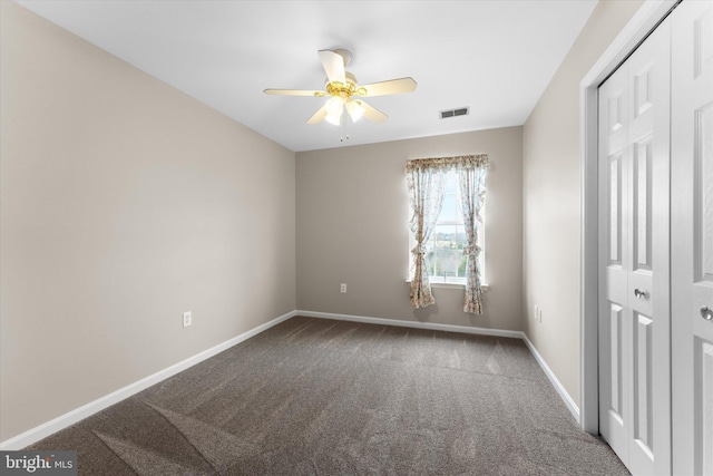 unfurnished bedroom with carpet flooring, a closet, baseboards, and a ceiling fan