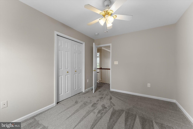 unfurnished bedroom with carpet flooring, a closet, baseboards, and ceiling fan