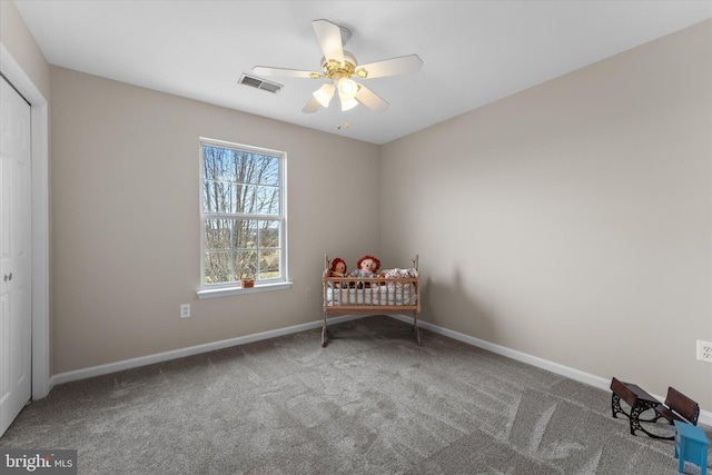 sitting room featuring carpet floors, a ceiling fan, and baseboards
