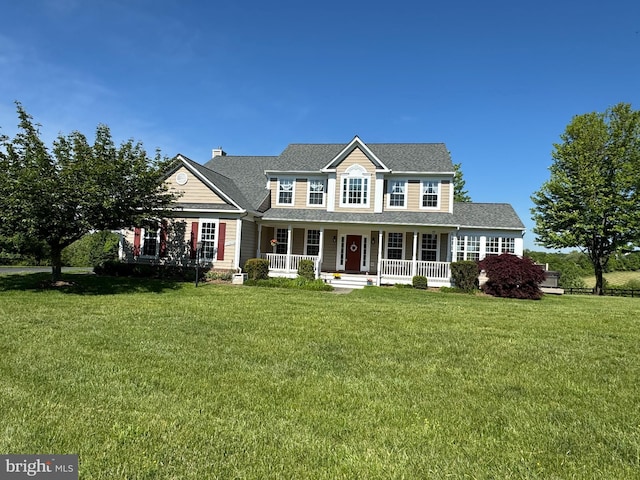 colonial-style house with a porch, a front yard, a chimney, and a shingled roof