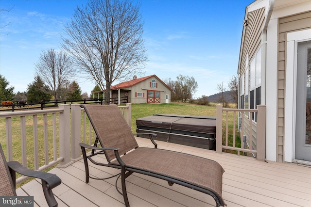 wooden terrace featuring a hot tub, a yard, and an outdoor structure