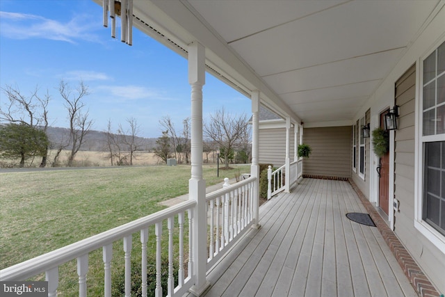deck featuring covered porch and a lawn