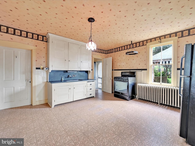 45 Front St, Lititz, PA 17543 - kitchen with radiator, black appliances, wallpapered walls, dark countertops, and white cabinetry