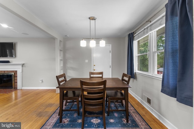 8313 Accotink Rd, Lorton, VA 22079 - dining space with wood finished floors, baseboards, and a brick fireplace