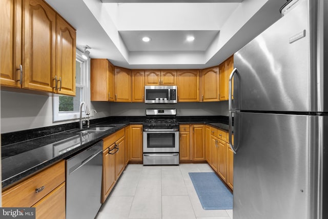 8313 Accotink Rd, Lorton, VA 22079 - kitchen featuring appliances with stainless steel finishes, a sink, brown cabinetry, light tile patterned floors, and recessed lighting