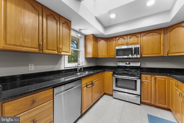 8313 Accotink Rd, Lorton, VA 22079 - kitchen featuring stainless steel appliances, a sink, brown cabinetry, a raised ceiling, and light tile patterned floors