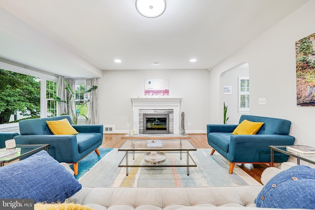 600 Saint Andrews Ln, Silver Spring, MD 20901 - living area featuring wood finished floors, arched walkways, a tiled fireplace, recessed lighting, and baseboards