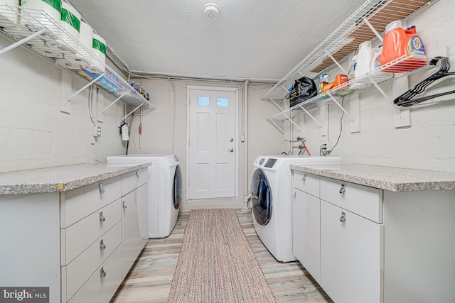 600 Saint Andrews Ln, Silver Spring, MD 20901 - washroom featuring washer and clothes dryer, light wood-style floors, and cabinet space