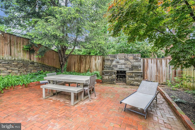600 Saint Andrews Ln, Silver Spring, MD 20901 - fenced backyard with outdoor dining space, a patio, and an outdoor stone fireplace