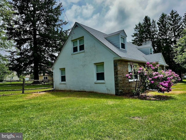 view of side of home with stone siding, a chimney, and stucco siding