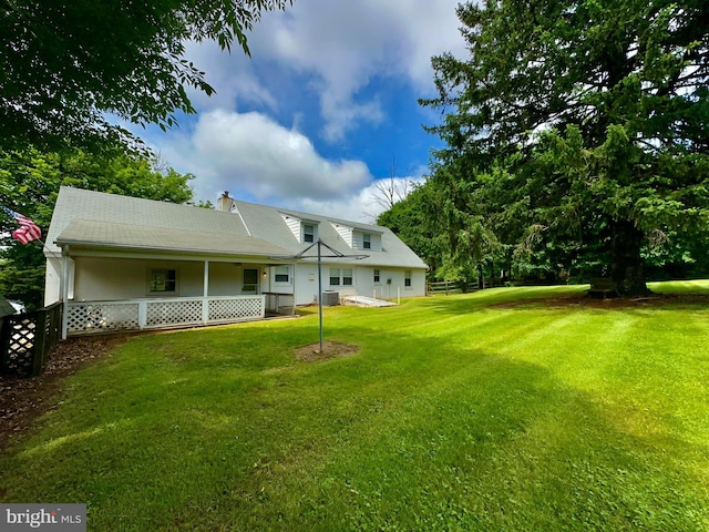rear view of property with a chimney and central air condition unit