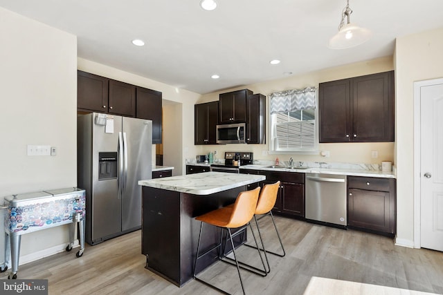 430 Mcwharton Way, Bunker Hill, WV 25413 - kitchen featuring appliances with stainless steel finishes, light wood finished floors, a center island, dark brown cabinetry, and a kitchen bar