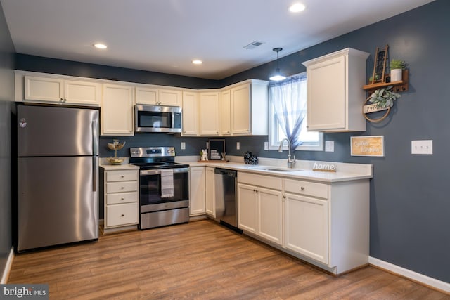 107 Arbutis Trl, Star Tannery, VA 22654 - kitchen featuring appliances with stainless steel finishes, a sink, light countertops, white cabinets, and wood finished floors