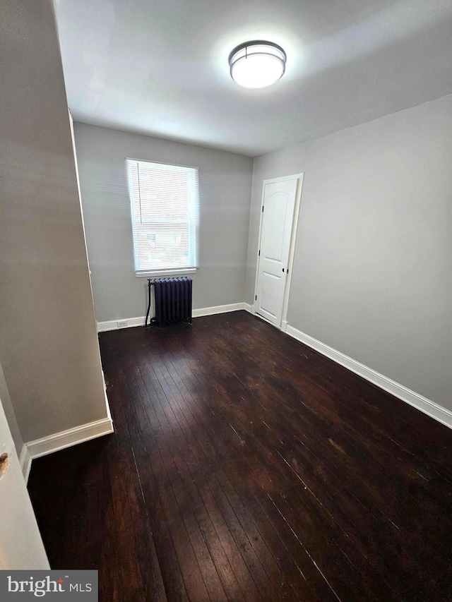 3404 Mueller St, Baltimore, MD 21224 - empty room featuring radiator, wood-type flooring, and baseboards