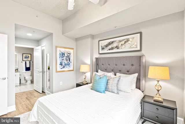 3600 S Glebe Rd Unit 605W, Arlington, VA 22202 - bedroom featuring light wood-type flooring, connected bathroom, baseboards, a textured ceiling, and ceiling fan