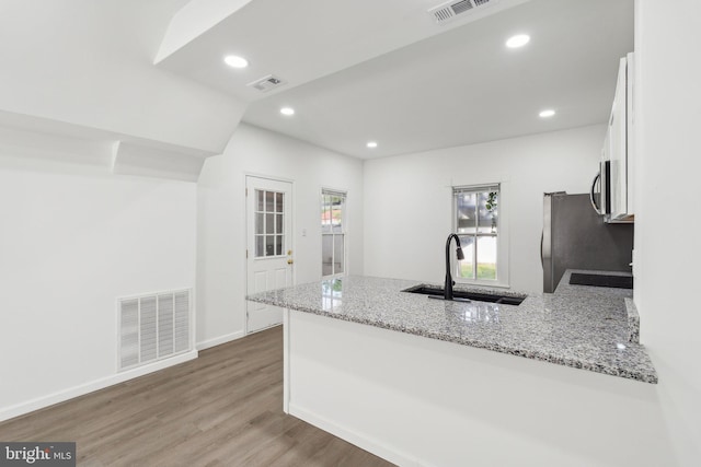 707 S Braddock St, Winchester, VA 22601 - kitchen with a peninsula, a sink, stainless steel appliances, white cabinetry, and healthy amount of natural light