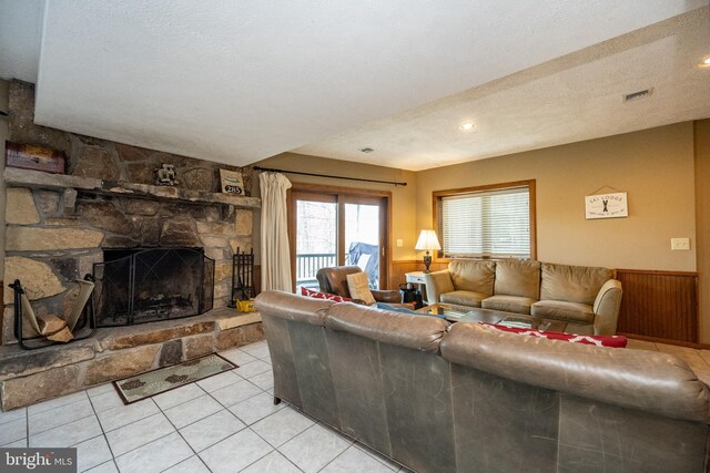 285 Cherry Heights Ln, Mc Henry, MD 21541 - living room with a stone fireplace, light tile patterned flooring, and a wainscoted wall