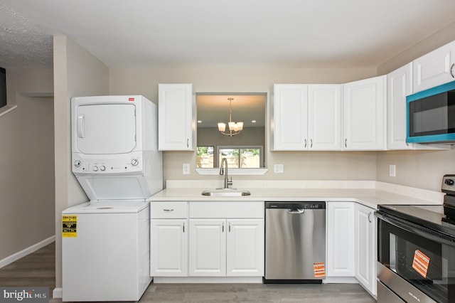 6 Keepsake Pl, Waldorf, MD 20602 - kitchen featuring appliances with stainless steel finishes, a sink, stacked washer / dryer, and white cabinets