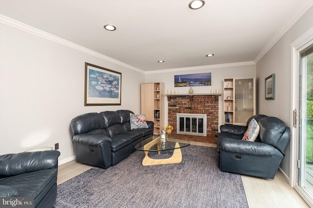 living area featuring light wood-style flooring, ornamental molding, a brick fireplace, recessed lighting, and baseboards