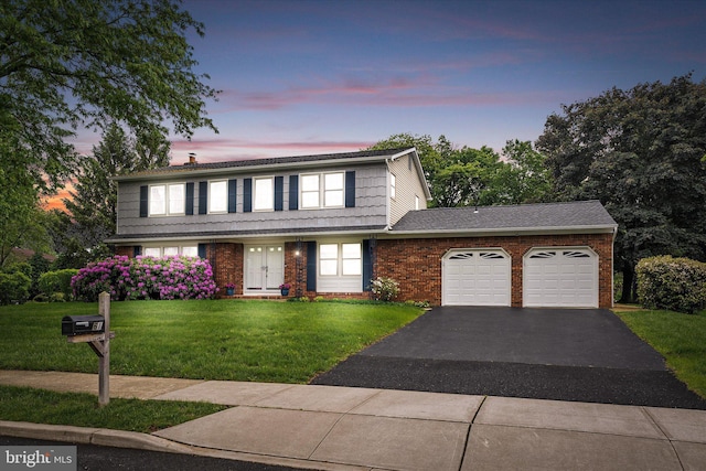 traditional-style house featuring a garage, driveway, a yard, brick siding, and a chimney