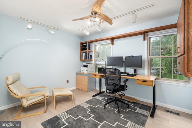 office space featuring rail lighting, ceiling fan, plenty of natural light, and light wood-type flooring