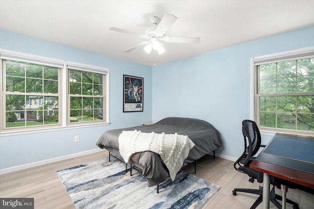bedroom with wood finished floors, baseboards, a desk, and a ceiling fan