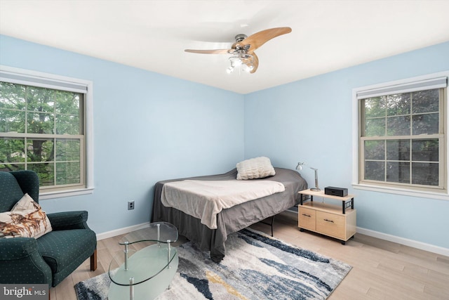 bedroom with wood finished floors, baseboards, and ceiling fan