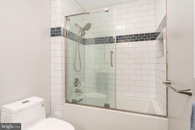 bathroom featuring toilet and combined bath / shower with glass door