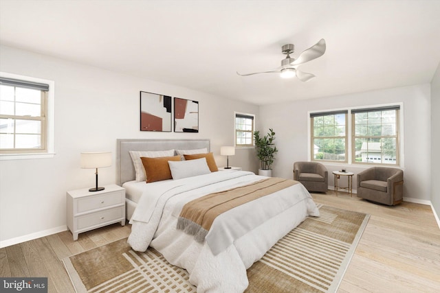 bedroom featuring light wood-style floors, baseboards, and a ceiling fan