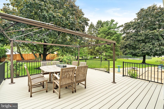 wooden deck featuring outdoor dining space and view of scattered trees