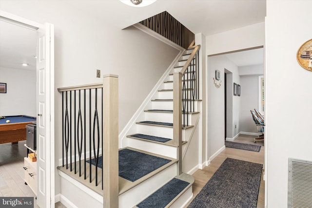 staircase featuring wood finished floors and baseboards