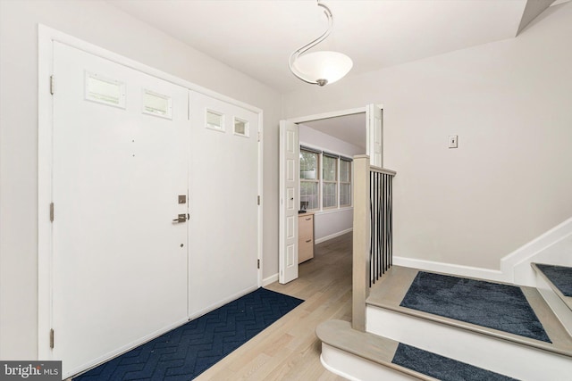 foyer with wood finished floors and baseboards