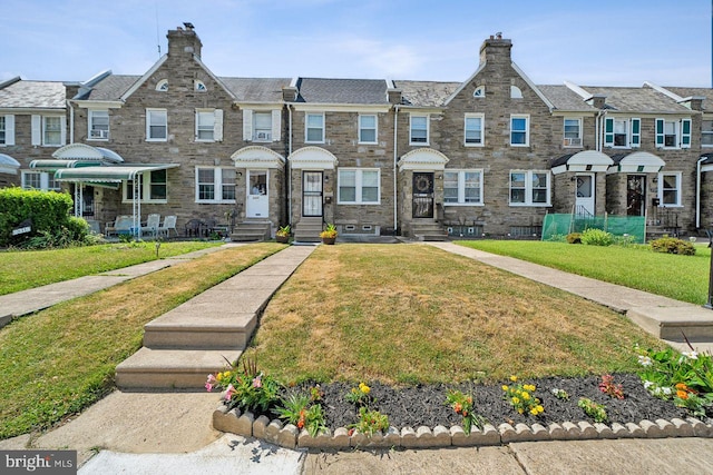 view of property with a front yard and entry steps