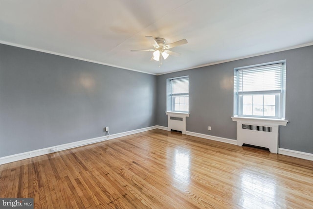 unfurnished room featuring radiator, ceiling fan, ornamental molding, light wood finished floors, and baseboards