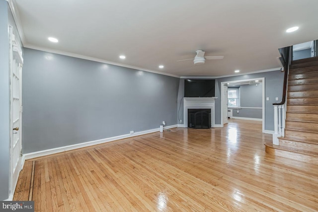 unfurnished living room featuring ornamental molding, a ceiling fan, stairs, light wood-style floors, and recessed lighting