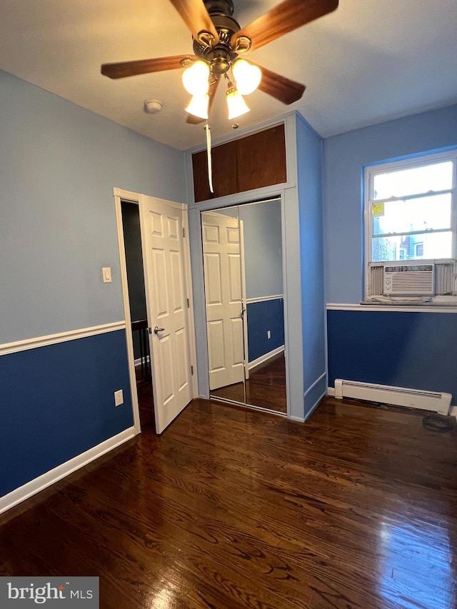 unfurnished bedroom featuring baseboard heating, wood finished floors, cooling unit, and baseboards