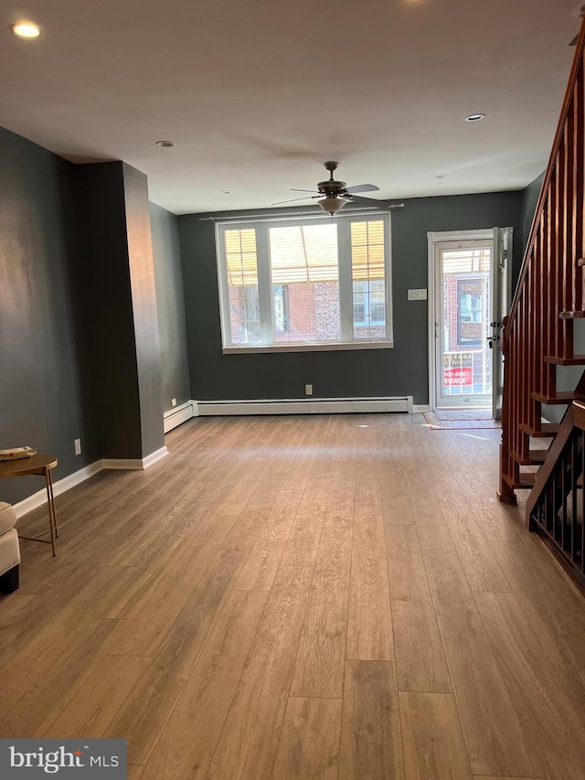 unfurnished living room featuring stairway, wood finished floors, a baseboard radiator, a ceiling fan, and recessed lighting